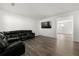 Open-concept living room with hardwood floors, and comfortable black leather sofa at 1183 Lanier Springs Dr, Buford, GA 30518