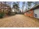 Large backyard with lawn extending from the side of a brick and siding home at 1893 Kenwood Se Rd, Smyrna, GA 30082