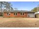 A grassy backyard extends from the rear of a brick and siding home with a dark roof at 1893 Kenwood Se Rd, Smyrna, GA 30082