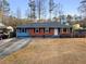 Charming single story home with a brick and siding exterior, front yard and long driveway at 1893 Kenwood Se Rd, Smyrna, GA 30082