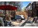 Outdoor seating area features a conversation set around a fire pit beneath a red umbrella and privacy fence at 1055 Amarose Ne Ln, Marietta, GA 30066