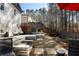 Multi-level backyard with stone patios, hanging egg chairs, lush trees, and privacy fencing at 1055 Amarose Ne Ln, Marietta, GA 30066