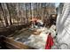 Inviting backyard featuring a stone patio, seating area with red umbrella, wooden fence, and lush trees at 1055 Amarose Ne Ln, Marietta, GA 30066