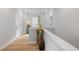 Upstairs hallway features a hardwood floor, window, and neutral paint at 1055 Amarose Ne Ln, Marietta, GA 30066