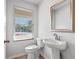 Well-lit half bathroom with pedestal sink, modern faucet, and attractive mirror at 1599 Sungrown Way, Mcdonough, GA 30253