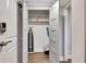 Hallway featuring an open storage closet with an ironing board, shelving, and cleaning supplies at 300 Peachtree Ne St # 6H, Atlanta, GA 30308