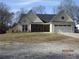 Charming single-story home boasts a two-car garage and inviting front facade with brick detailing at 561 Old Loganville Rd, Loganville, GA 30052