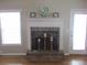 Cozy fireplace with brick hearth, white mantle, and natural light streaming in from nearby windows at 561 Old Loganville Rd, Loganville, GA 30052