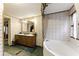 Bathroom featuring double sinks, a soaking tub, and charming wallpaper, creating a vintage-inspired space at 1515 Ozora Rd, Loganville, GA 30052