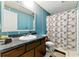 Bathroom with blue walls, a single vanity, and a shower with curtain, providing essential amenities at 1515 Ozora Rd, Loganville, GA 30052