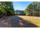 Open plot of land surrounded by trees, ideal for development or recreational use, under a blue sky at 1515 Ozora Rd, Loganville, GA 30052