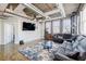 Open-concept living room with exposed ductwork, ceiling fan, large TV, and comfortable gray sectional sofa at 244 Peters St # 23, Atlanta, GA 30313