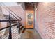 Exposed brick staircase with a black metal railing and artwork at 244 Peters St # 23, Atlanta, GA 30313