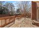 A wooden back deck with railings offers a backyard view with a brick wall at 2976 Wilsons Crossing Ct, Decatur, GA 30033