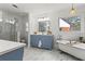Updated bathroom with a standalone tub, modern shower, blue vanity, and marble floors at 2976 Wilsons Crossing Ct, Decatur, GA 30033