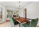 Bright dining room featuring hardwood floors, wainscoting, an elegant light fixture, and a rustic wood table with plush green seating at 2976 Wilsons Crossing Ct, Decatur, GA 30033