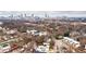 Wide aerial perspective showcases homes in a wooded setting with a vibrant cityscape in the distance at 1100 Arkwright Se Pl # B, Atlanta, GA 30316