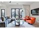 Comfortable living room with a plush couch, orange chairs, and a round glass table at 1100 Arkwright Se Pl # B, Atlanta, GA 30316