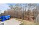 Backyard featuring a wood fence, trees, and a covered motorcycle at 5015 Rapahoe Trl, Atlanta, GA 30349