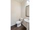 Powder room featuring a white pedestal sink and matching toilet with hardwood floors at 5015 Rapahoe Trl, Atlanta, GA 30349