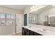 Bathroom with double vanity, large mirror, and a shower with glass door at 5015 Rapahoe Trl, Atlanta, GA 30349