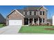 Beautiful two-story brick home with a well-manicured lawn and an attached two-car garage at 718 Ocmulgee Crossing, Locust Grove, GA 30248
