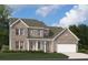 Charming two-story brick home with a well-manicured lawn and an attached two-car garage at 718 Ocmulgee Crossing, Locust Grove, GA 30248