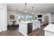Open kitchen with a large island, stainless steel appliances, and a view of the living area at 718 Ocmulgee Crossing, Locust Grove, GA 30248