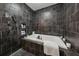 Close-up of luxurious black tiled shower and bath with decorative stone floors and built in shelves at 101 Bevil Ridge Se Rd, Emerson, GA 30137