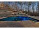 Beautiful pool area featuring a brick retaining wall, stone patio, lounge chairs and umbrellas at 101 Bevil Ridge Se Rd, Emerson, GA 30137