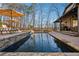 Backyard pool with stone retaining wall, umbrellas, lounge chairs, and a house in the background at 101 Bevil Ridge Se Rd, Emerson, GA 30137
