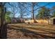 Large backyard with fire pit seating, wooden privacy fence, and storage shed at 1475 Elizabeth Ln, East Point, GA 30344