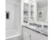 Bathroom featuring a bathtub, granite countertop vanity, built-in storage and white tile at 198 Ponce De Leon Ne Ave # 2A, Atlanta, GA 30308