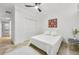 Bright bedroom featuring a white bed, ceiling fan, white walls, and travertine tile flooring near a closet at 198 Ponce De Leon Ne Ave # 2A, Atlanta, GA 30308