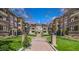 Attractive brick apartment buildings with arched entryway and well-manicured landscaping under a bright blue sky at 198 Ponce De Leon Ne Ave # 2A, Atlanta, GA 30308