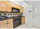 Compact kitchen featuring black appliances, light wood cabinetry, and a decorative backsplash for a charming touch at 198 Ponce De Leon Ne Ave # 2A, Atlanta, GA 30308