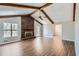 Bright living room featuring vaulted ceilings, wood beams, and a brick fireplace at 12142 Panhandle Rd, Hampton, GA 30228