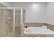 Bathroom with shower and separate soaking tub featuring neutral tile surround at 2275 W Village Se Ln, Smyrna, GA 30080