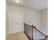 Upstairs hallway features a closet and carpet flooring with a wrought iron railing and wood trim at 2275 W Village Se Ln, Smyrna, GA 30080
