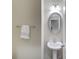 A powder room features a pedestal sink, oval mirror and stylish lighting fixture at 2275 W Village Se Ln, Smyrna, GA 30080