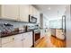 Contemporary kitchen boasting stainless steel appliances, granite countertops, and stylish white cabinetry and hardwood floors at 1580 Commerce Dr # A8, Decatur, GA 30030