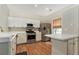 Modern kitchen features stainless steel appliances, white cabinets, and wood flooring at 2280 Whitestone Pl, Alpharetta, GA 30005