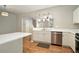 Well-lit kitchen boasts stainless steel appliances, white cabinets, and a convenient breakfast bar at 2280 Whitestone Pl, Alpharetta, GA 30005