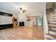 Spacious living room showcasing wood floors, a fireplace, and staircase with patterned steps at 2280 Whitestone Pl, Alpharetta, GA 30005
