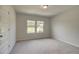 Bedroom with a large window, neutral carpet, and a closet door with white trim at 30 Homesite Cooper E Cv, Fayetteville, GA 30215