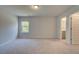 Large, bright bedroom featuring neutral carpet, a window, and doorway to the attached bathroom at 30 Homesite Cooper E Cv, Fayetteville, GA 30215