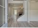 Elegant entryway showcasing hardwood floors, stairs with black iron spindles and living area at 30 Homesite Cooper E Cv, Fayetteville, GA 30215