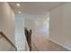 Bright hallway with carpeted floors, recessed lighting, and decorative wood banister on the staircase at 30 Homesite Cooper E Cv, Fayetteville, GA 30215