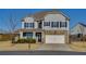Charming two-story home with a stone facade and well-manicured lawn in a suburban neighborhood at 4675 Dandelion Way, Cumming, GA 30040