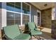 Inviting front porch featuring cozy seating, a stone facade, and ample natural light at 4675 Dandelion Way, Cumming, GA 30040